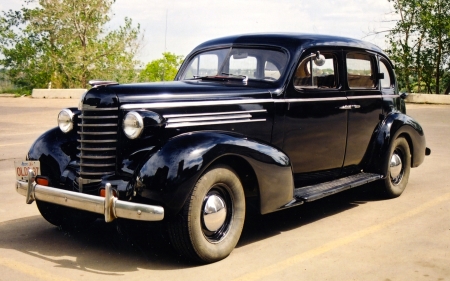 The 1937 Oldsmobile [assembled in Regina, Saskatchewan, incidentally]. This photo was taken before Mr. Rust attacked the wheel wells. Now there's a guy people should put a contract on.