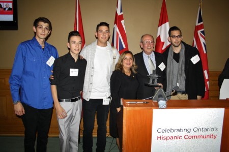Pastor Valle-Garay receiving an award from the Province of Ontario. He is with his four sons.
